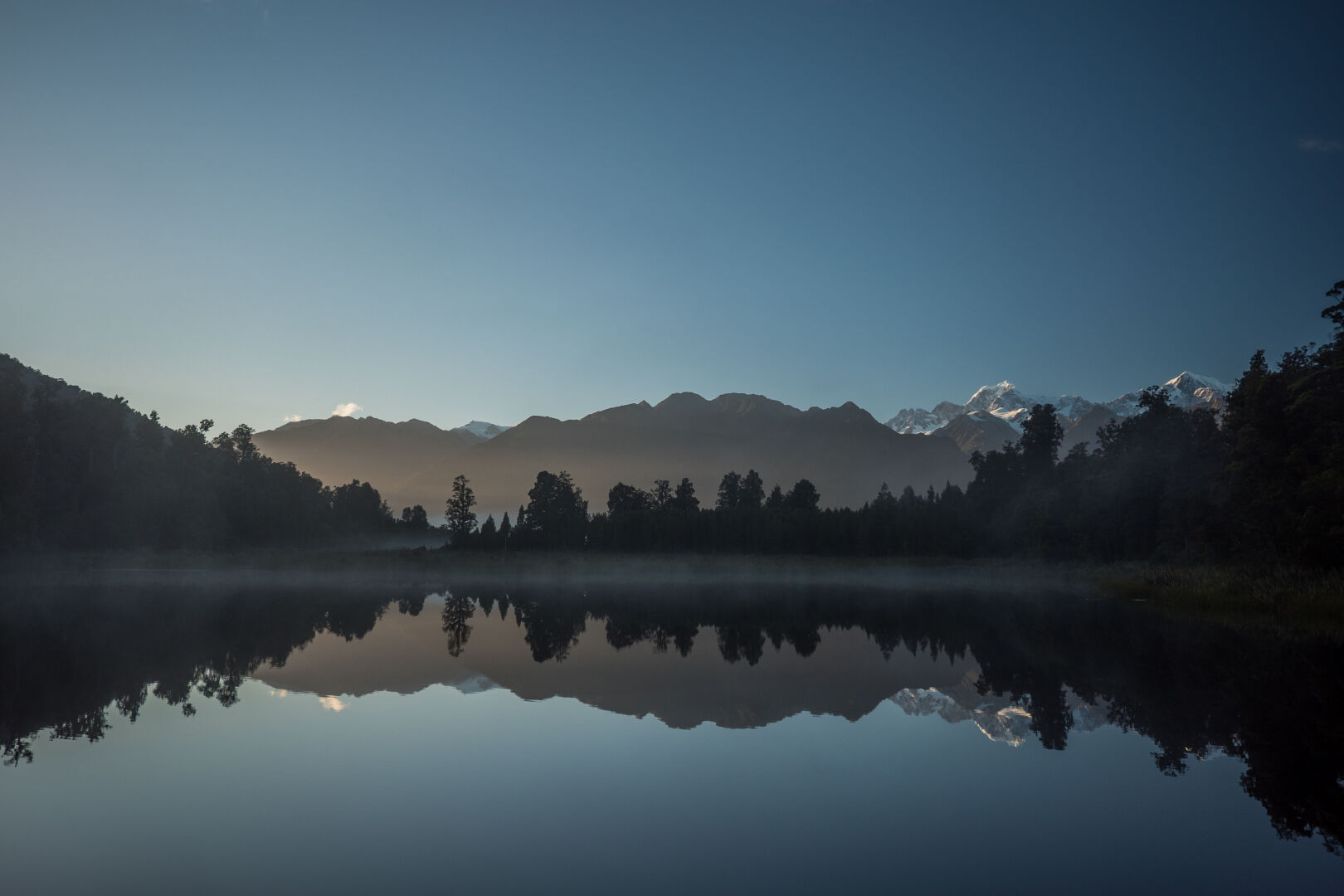 A lake mirroring the mountains in the background perfectly