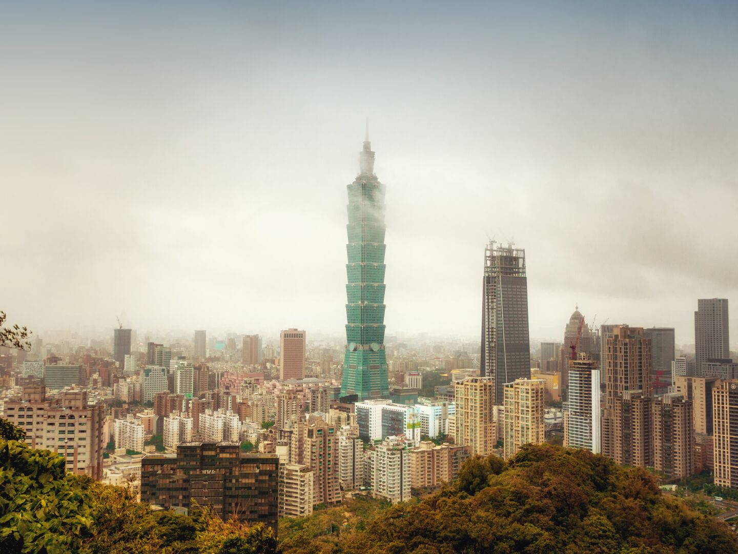Skyscrapers partly in the clouds above a big city with no end in sight
