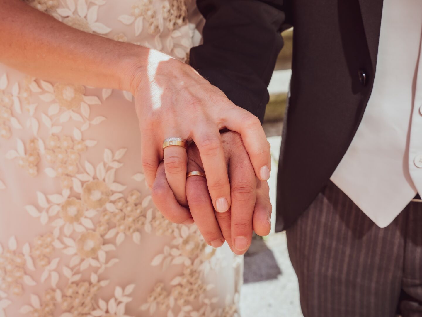 Bride and groom holding hands, showing their new rings